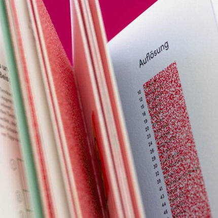 Abgebildet ist ein aufgeschlagenes Buch. Im Fokus stehen die „Auflösungen und dazugehörige Seitenzahl“ zu den Fragen im Buch.